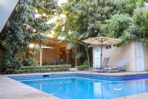 巴耶斯城Hotel Casa Ortiz的一个有两把椅子和一把遮阳伞的游泳池