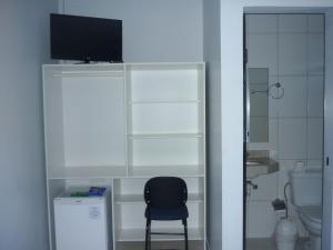 a black chair sitting in a room with a bathroom at Via Norte Hotel in Gurupi