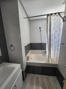a bathroom with a tub and a sink and a shower at Residence NADINE CHATT MARIEM SOUSSE in Bin Rhilouf