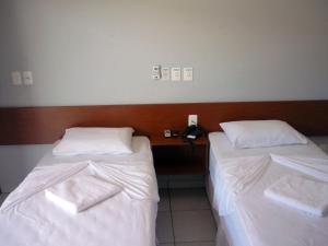 two beds in a hotel room with a telephone at Via Norte Hotel in Gurupi