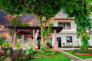 a building with trees and plants in front of it at THE OASIS RESORT CondoBimbo 1-Big Room, Balcony, kitchen, Pool, Wifi, Videoke in San Fernando