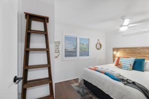 a bedroom with a ladder next to a bed at Quirky Black Shack in Burnett Heads