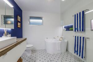 a bathroom with a white sink and a toilet at Quirky Black Shack in Burnett Heads +31 photos