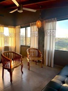 two chairs and a couch in a room with windows at Cabaña Casa Flor Bru in Villa Yacanto