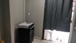 a small kitchen with a black curtain and a window at Apto privativo in Rio Branco