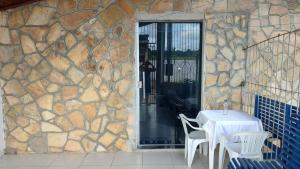 a table and chairs in front of a stone wall at Apto privativo in Rio Branco