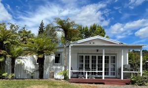 OngarueOngarue Cottage的白色的房子,设有门廊和棕榈树