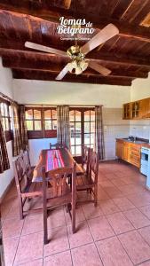 ein Esszimmer mit einem Tisch und einem Deckenventilator in der Unterkunft Lomas de Belgrano Oficial cabaña 1 in Villa General Belgrano
