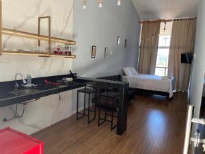 a kitchen with a black counter and a living room at Skyloft in Governador Valadares