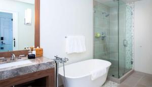 a bathroom with a tub and a glass shower at Carmel Beach Hotel in Carmel +24 photos