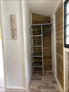 Habitación con armario y paredes de madera. en Gwada-Zen-Breizh 3 hébergements au choix 1 avec piscine privée, 1 avec jacuzzi privé, 1 simple sans piscine ni jacuzzi, en Deshaies