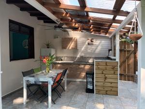 Una cocina y un comedor con mesa y sillas. en Gwada-Zen-Breizh 3 hébergements au choix 1 avec piscine privée, 1 avec jacuzzi privé, 1 simple sans piscine ni jacuzzi, en Deshaies