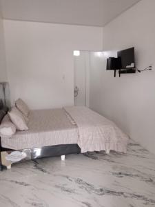 a bedroom with a bed in a white room at LA97 Homestay in Berastagi