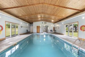 an indoor swimming pool with a wooden ceiling and windows at Ambassador Motel in Sault Ste. Marie