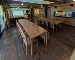 Un comedor con una gran mesa y sillas de madera. en 最大23名宿泊 源泉温泉 ホームシアター 客室8部屋 那須グリーン温泉, en Nasu
