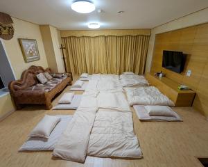 una cama grande en una habitación con un sofá en 最大23名宿泊 源泉温泉 ホームシアター 客室8部屋 那須グリーン温泉, en Nasu 45 fotos más