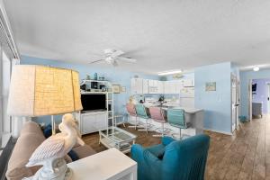 ein Wohnzimmer mit Sofa und Tisch in der Unterkunft Peachtree Place Ii C202 in Panama City Beach