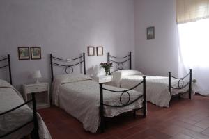 a bedroom with two beds and a window at Borgo al Cielo - Albergo Diffuso in Suvereto +59 photos