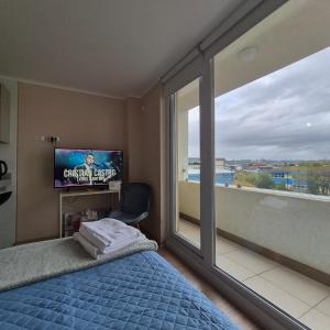 a bedroom with a bed and a tv and a window at Departamento Central Osorno 2 in Osorno