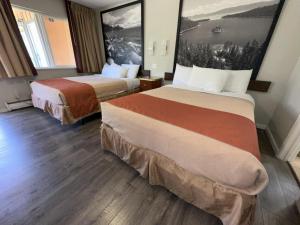 a hotel room with two beds and a painting on the wall at Alpine Inn & Spa in South Lake Tahoe