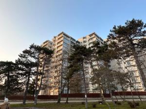 a tall building with trees in front of it at Apartment Happiness by Nicole Jutka, visual artist Olimp in Olimp