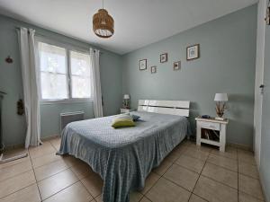 a bedroom with a bed and a window at Maisonnette près du centre, proche plage et commerces - FR-1-476-84 in LʼAiguillon-sur-Mer