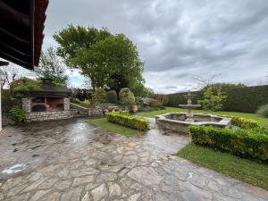 a garden with a fountain and a cross in the yard at Appartement avec jardin et piscine privée à Ciboure - FR-1-239-1121 in Ciboure