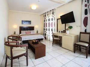 a hotel room with a bed and a desk at Hotel Astron in Karditsa