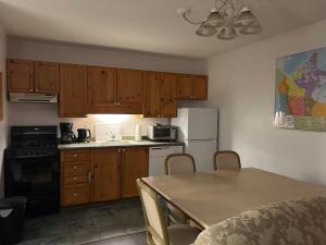 a small kitchen with wooden cabinets and a table with chairs at New Management - Collingwood Getaway in Collingwood