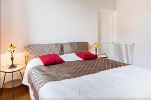 ローマにあるElegant apartment near the Vatican and Piazza Navonaのベッドルーム1室(大型ベッド1台、赤い枕2つ付)