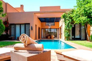 une maison avec une piscine en face de celle-ci dans l'établissement Al Maaden Villa Hotel & Spa, à Marrakech