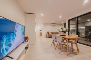 a dining room with a large tv and a table at Central 1BR - Bath BBQ & Full Kitchen in Christchurch