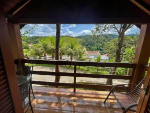 a view from the porch of a house with chairs at Pousada Pé da Serra in Lindóia
