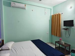 a bedroom with a bed and a tv on the wall at MAYUR paying Guest house in Varanasi