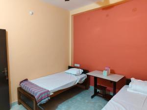 a small room with two beds and a table at MAYUR paying Guest house in Varanasi