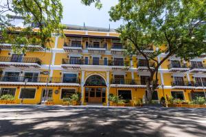 Un edificio amarillo con un árbol delante. en La Moon Puducherry, en Pondicherry