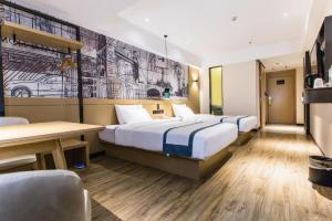 a hotel room with two beds and a table at City Comfort Inn Nanning Shuangyong Road Guangxi Medical University in Nanning +165 photos