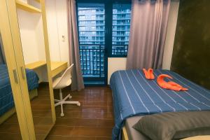 a room with a bed with orange shoes on it at The Comfy Cove Swim Stream in Central Makati 2272 in Manila