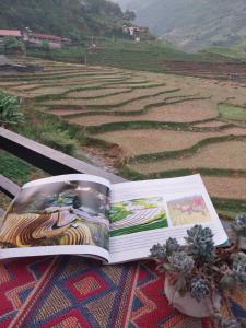 an open book sitting on a table next to a field at Hương siu homestay in Mù Cang Chải