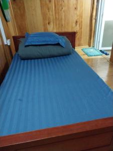 a bed with a blue blanket on top of it at Hương siu homestay in Mù Cang Chải