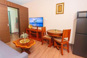 a living room with a table and a refrigerator at Sunlit Makati Haven Cozy 1BR Gym Pool 1703 in Manila