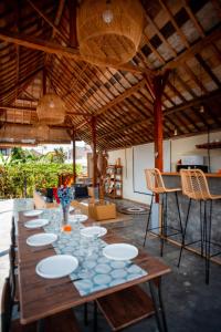 a long wooden table with plates on it in a room at Nila Chandra Bungalows in Ubud