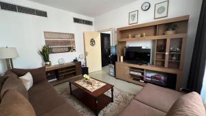 a living room with a couch and a tv at XD Cozy Apartments in Abu Dhabi