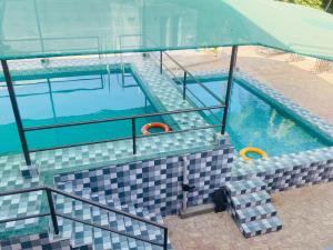 an overhead view of a swimming pool with an umbrella at Prashiv farm stay in Talala