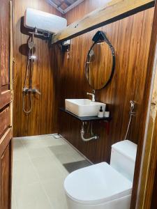 a bathroom with a sink and a toilet and a mirror at Voi Vui Vẻ Homestay in Plei Kêp