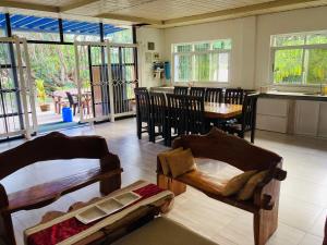 uma sala de estar com mesas e cadeiras e uma cozinha em The poolhouse at McKirdy's mango farm em Sison mais 21 fotografias