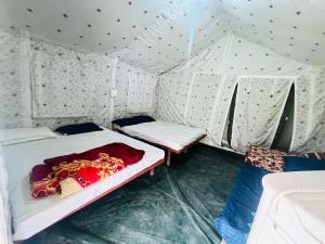 a room with two beds in a tent at Nimay camp resort in Jāmb
