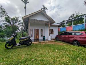 a small house with a scooter parked in front of it at Rumah Liburan Sikabu-kabu in Airtabit