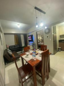 a dining table and chairs in a living room at M&N Condotel in Manila