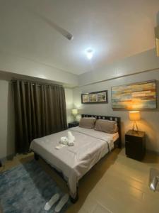 a bedroom with a bed with two towels on it at M&N Condotel in Manila